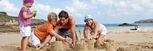 famille avec deux enfants jouant dans le sable des plages bretonnes