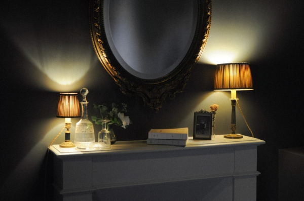 decor de lampe sur cheminée surmonté d'un miroir dorée