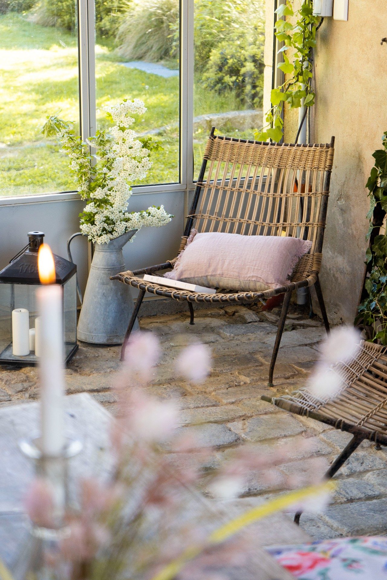 fauteuil en osier dans jardin d'hiver